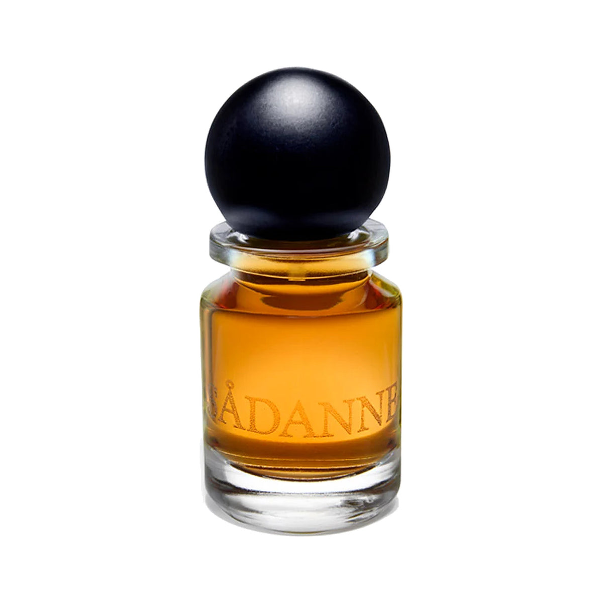 Sådanne by Slumberhouse, amber perfume in a squat glass bottle etched with its name, under a black ball cap