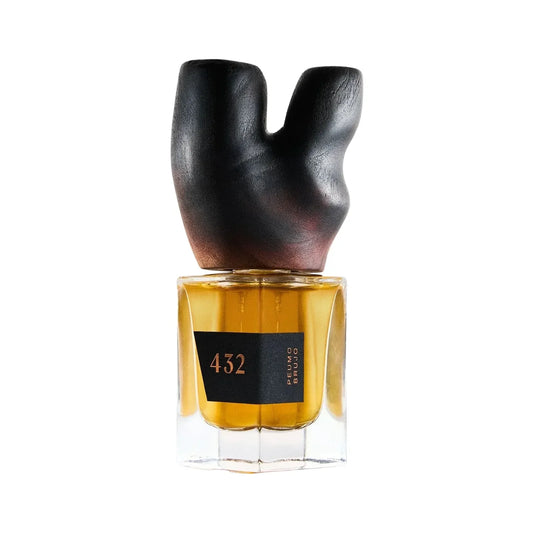 Peumo Brujo by 432, a square bottle of amber perfume with a black 432 label, crowned with a carved, charred-dark wooden stopper shaped like a forked branch