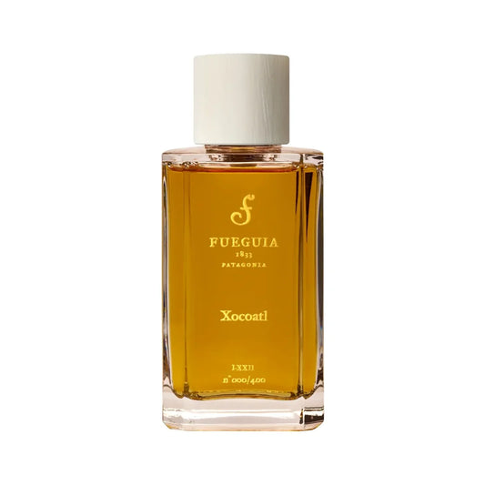 Xocoatl by Fueguia 1833, a tall rectangular bottle of golden amber juice with a white wooden cap and gold Fueguia lettering